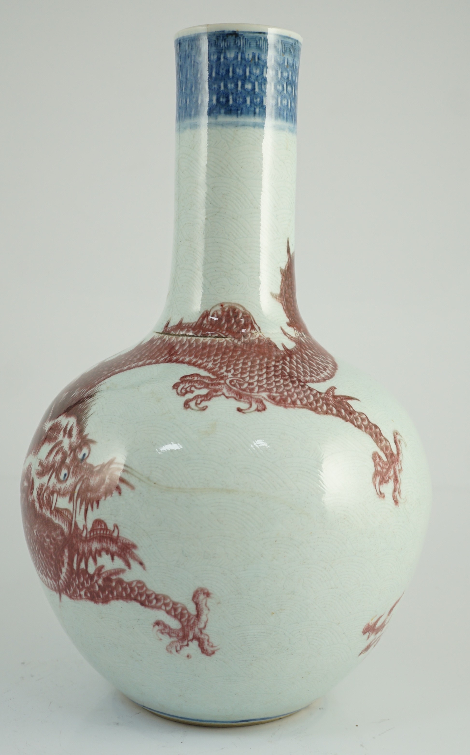 A rare Chinese underglaze blue and copper red 'dragon' vase, tianqiuping, 18th century, 38cm high, firing faults, hairline cracks